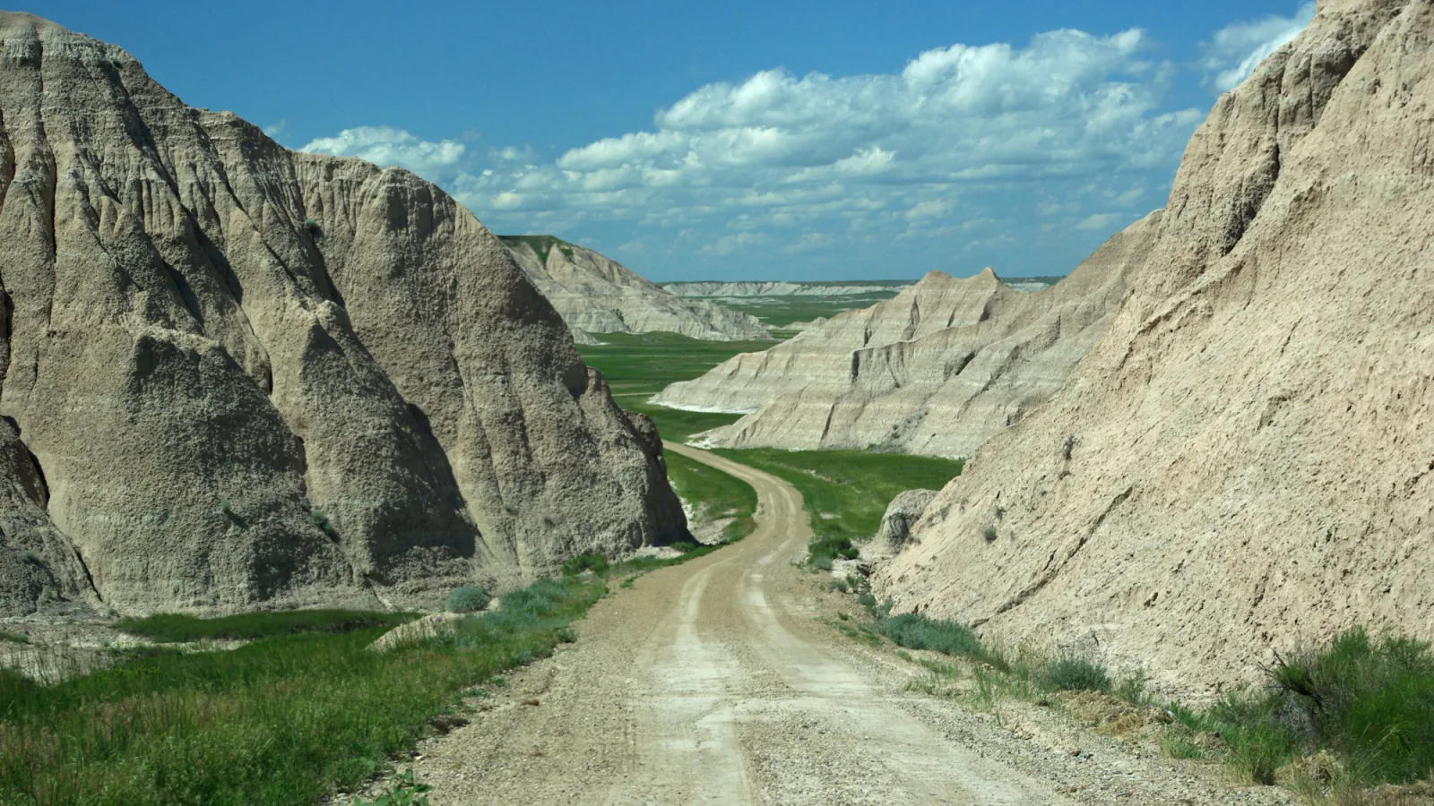 A quiet road threading through eroded rock formations in Badlands National Park