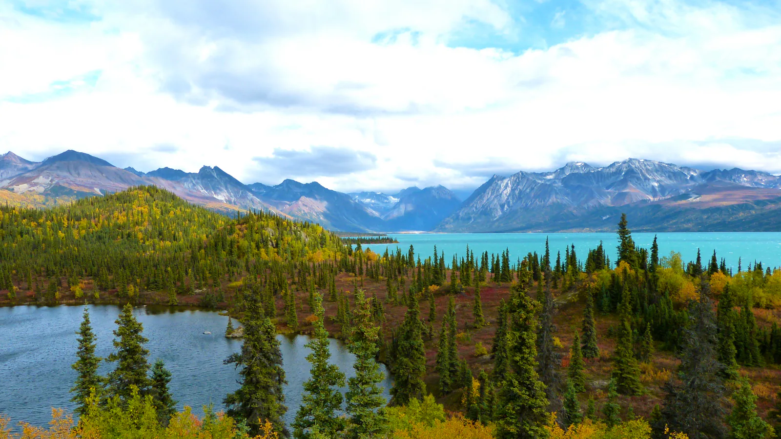 A mountain ridge rises above blue water in Lake Clark National Park and Preserve