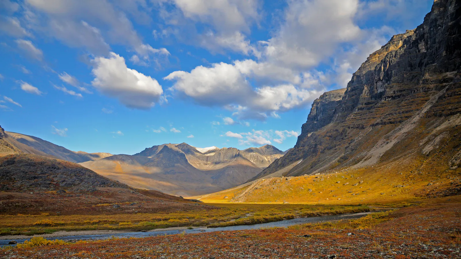 Sharp granite peaks rise above a broad tundra valley in Gates of the Arctic National Park