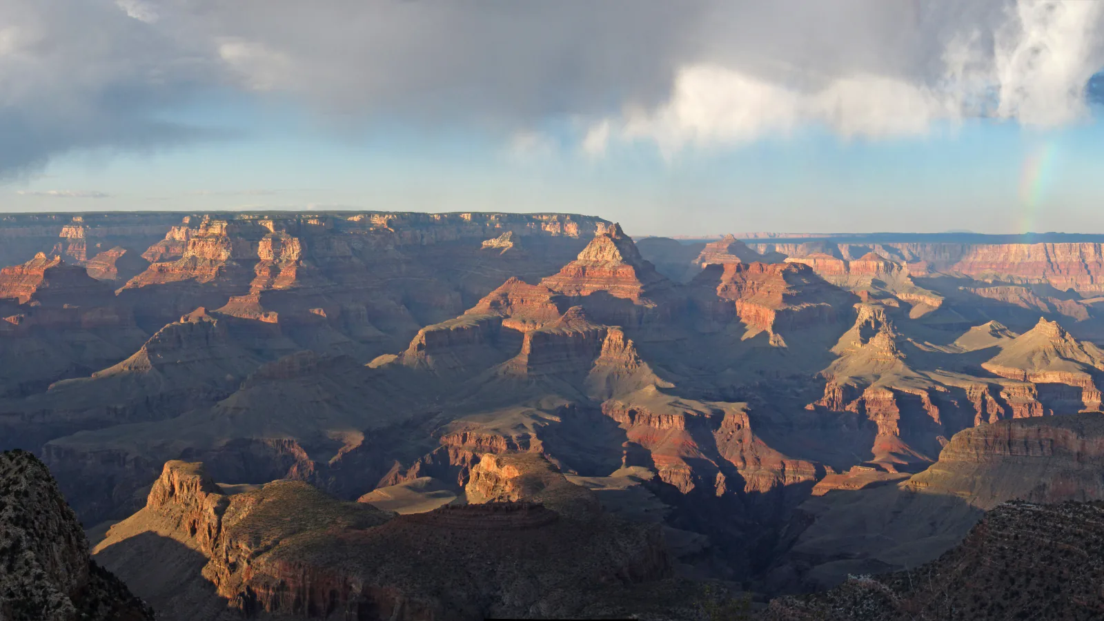 Sunlit buttes beneath a passing rainstorm in Grand Canyon National Park